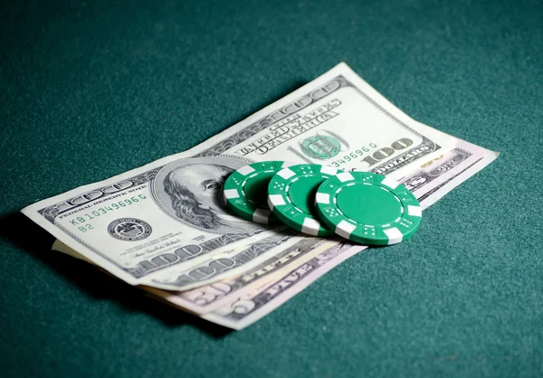 Primer plano pila de fichas de casino y billetes de dólar en la mesa de póquer — Foto de Stock