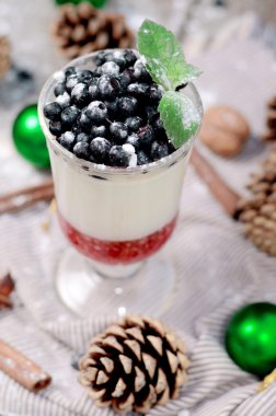 Lezzetli parfe tatlı sufle ve jöle katmanları bilberry ile süt. Rustik ahşap zemin üzerine bir bardak dondurulmuş muamele etmek