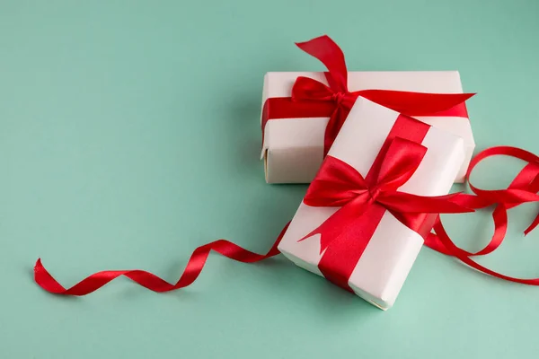 两个白色礼品盒 蓝色背景上有明亮的红色蝴蝶结 并留有文字空间 圣诞和新年横幅不错 — 图库照片
