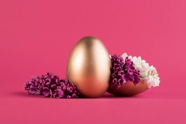 Mor eflatun süslemelerle süslenmiş altın sarısı Paskalya yumurtası. Mutlu Paskalya trendi minimalist arkaplanı.