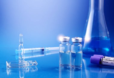 Laboratuvarda laboratuvar mataralarına enjekte etmek için sıvı içeren cam ampuller. Koronavirüs aşısı Covid-19 teması