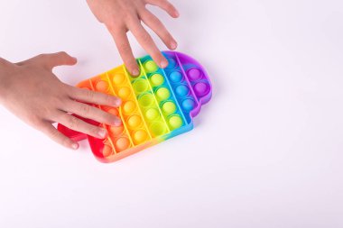 Çocuklar gökkuşağı oyuncağıyla oynuyorlar. Oyuncak beyaz renkte izole edilmiş..