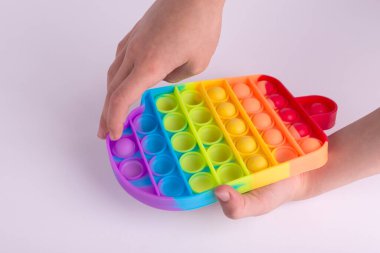 Çocuklar gökkuşağı oyuncağıyla oynuyorlar. Oyuncak beyaz renkte izole edilmiş..