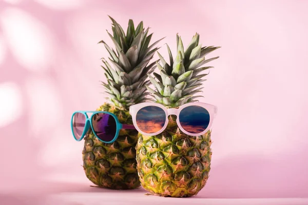 Frische reife Ananas mit Sonnenbrille vor rosa Hintergrund. Hallo, Sommer- oder Sommersaisonverkauf. — Stockfoto