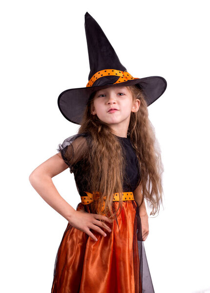 Happy laughing little girl wearing a witch carnival costume playing with a basket for treats. Child girl Halloween kid against a white background.