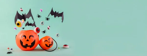 Feliz día de Halloween banner con calabazas lindas, papel volador murciélagos cortados, dulces y arañas contra el azul claro con espacio vacío para el texto. —  Fotos de Stock