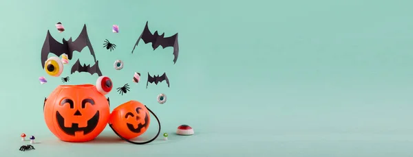 Feliz día de Halloween banner con calabazas lindas, papel volador murciélagos cortados, dulces y arañas contra el azul claro con espacio vacío para el texto. —  Fotos de Stock