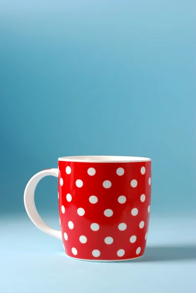 Taza roja de leche sobre un fondo azul — Foto de Stock