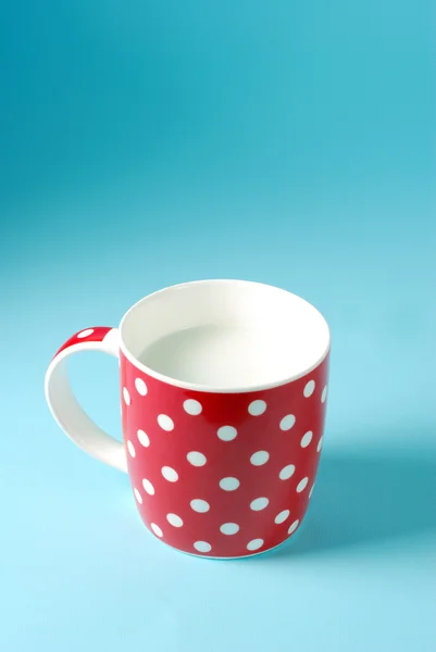 Piros pohár tej, kék háttérrel — Stock Fotó