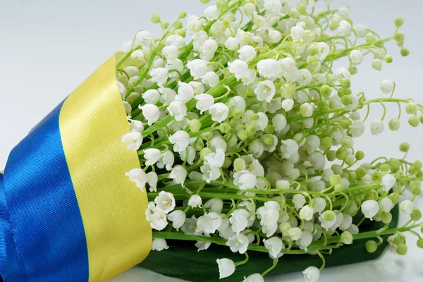 Kytici Konvalinka vztahuje ukrajinské vlajky. — Stock fotografie