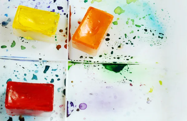 Árbol brillantes cajas de acuarela en una caja de pintura con salpicaduras de colores — Foto de Stock