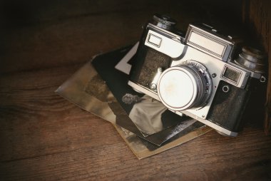 Rustik ahşap tahta, antika arka plan üzerinde eski fotoğraflarla Retro kamera