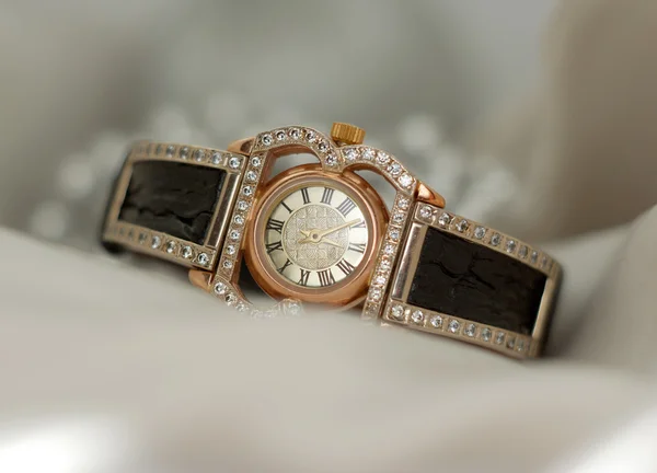 Beautiful old vintage gold watches with sparkling gem stones on a soft bokeh background — Stock Photo, Image