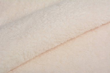 bej rengi Karakul Soyut Yapay Yapay Yapay Doku Kürk Kumaşı, Arka plan, Yakın plan. Yumuşak malzeme arka plan, çocuk oyuncakları sahte kürk.