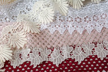 Bir yığın kırmızı, beyaz. Bej rengi yelken şampanyası lüks, lüks, gri arka planda dantel kumaş. giysi dikmek için keten dekorasyonunu kullan.