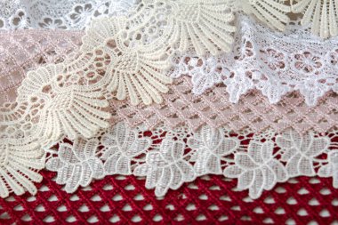 Bir yığın kırmızı, beyaz. Bej rengi yelken şampanyası lüks, lüks, gri arka planda dantel kumaş. giysi dikmek için keten dekorasyonunu kullan.