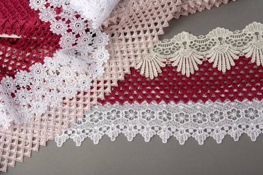 Bir yığın kırmızı, beyaz. Bej rengi yelken şampanyası lüks, lüks, gri arka planda dantel kumaş. giysi dikmek için keten dekorasyonunu kullan.