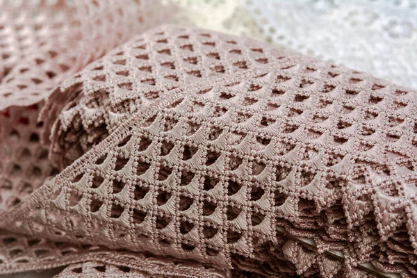 close up of pink beige set sail champagne gentle luxury quality guipure, lace fabric on gray background. use for sew clothes linen decoration.