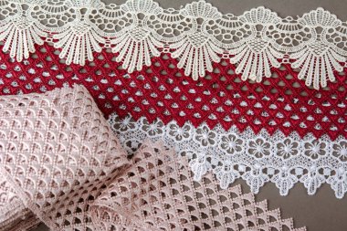 Bir yığın kırmızı, beyaz. Bej rengi yelken şampanyası lüks, lüks, gri arka planda dantel kumaş. giysi dikmek için keten dekorasyonunu kullan.