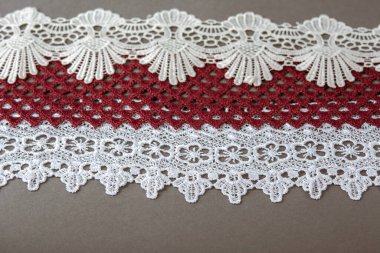 Bir yığın kırmızı, beyaz. Bej rengi yelken şampanyası lüks, lüks, gri arka planda dantel kumaş. giysi dikmek için keten dekorasyonunu kullan.