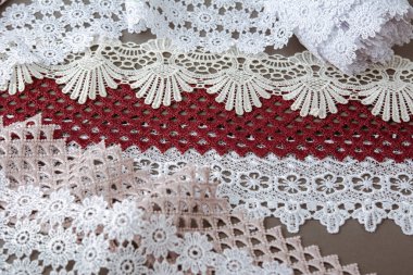 Bir yığın kırmızı, beyaz. Bej rengi yelken şampanyası lüks, lüks, gri arka planda dantel kumaş. giysi dikmek için keten dekorasyonunu kullan.