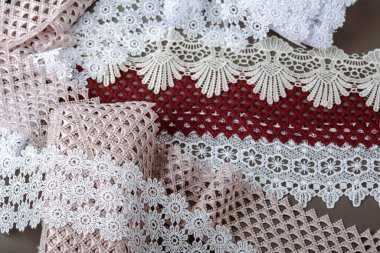 Bir yığın kırmızı, beyaz. Bej rengi yelken şampanyası lüks, lüks, gri arka planda dantel kumaş. giysi dikmek için keten dekorasyonunu kullan.