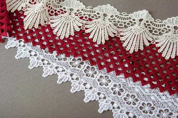 Bir yığın kırmızı, beyaz. Bej rengi yelken şampanyası lüks, lüks, gri arka planda dantel kumaş. giysi dikmek için keten dekorasyonunu kullan.