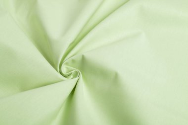 Yeşil pamuk doğal kumaş, ipliklerin dokuması, kıvrımlı kıvrımlar. Elbise ve gömlek dikmek için. Dikiş dikmek ve terzi dükkanını kullanmak için. Metin için boşluk.