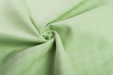 Yeşil pamuk doğal kumaş, ipliklerin dokuması, kıvrımlı kıvrımlar. Elbise ve gömlek dikmek için. Dikiş dikmek ve terzi dükkanını kullanmak için. Metin için boşluk.