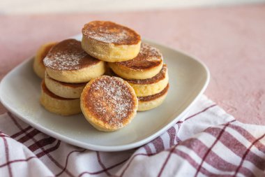 Ev yapımı Pile Pluffy Sufle Pancake, badem, hindistan cevizi, soya unu. Tatlı pudrayla yakın çekim. Beyaz tabakta, pembe grunge betonda ketojenik yiyecekler. Tekstil pamuk havlu. Japon Biçimli Tatlı.