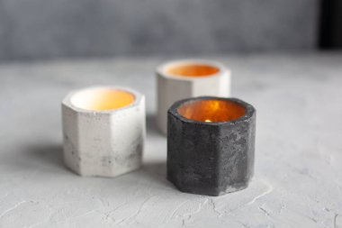 Soyut lekeli tek renkli taş mum tutucu seti, sarı ışıkla gri betonu çatlatıyor. Saksı, saksı ve dekorasyon için kullanılıyor. metin için boşluk kopyala, seçici yumuşak odak