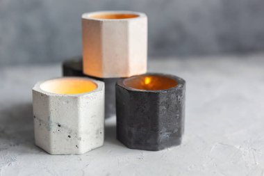 Soyut lekeli tek renkli taş mum tutucu seti, sarı ışıkla gri betonu çatlatıyor. Saksı, saksı ve dekorasyon için kullanılıyor. metin için boşluk kopyala, seçici yumuşak odak