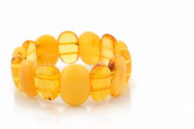 Doğal cilalanmış, şeffaf bal rengi, lüks boncuklardan yapılmış bilezik. Beyaz boncuklar da dahil. Seçici yumuşak odaklanmayı kapat. Metin için boşluk