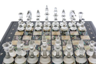 Şeffaf farklı cam satranç taşları beyaz inci tahtanın üzerinde duruyor. Parıltılı ve mat şekilli. oyun karşılaşma konsepti.