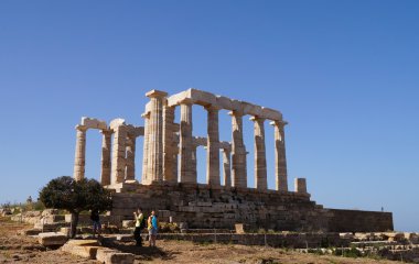 Turistler Cape Sounion, Yunanistan'da Poseidon Tapınağı ziyaret.