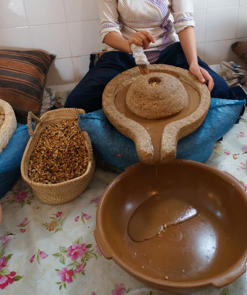 Un trabajador marroquí preparando aceite de argán —  Fotos de Stock