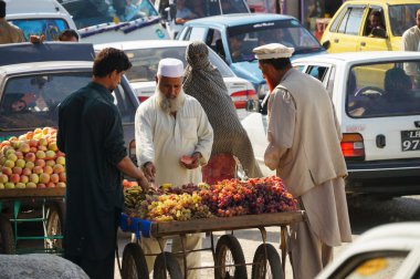 Kimliği belirsiz Pakistan adam Besha pazarda, taze meyve satıyor