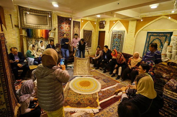 Turistas desconhecidos visitando loja de tapetes em Isfahan, Irã . — Fotografia de Stock