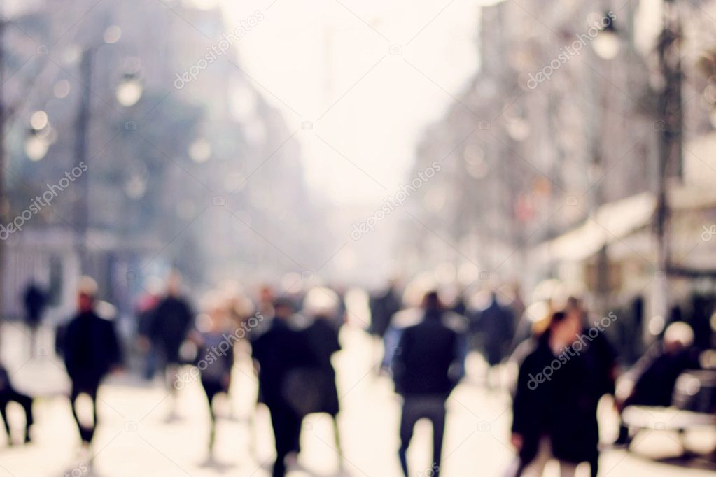 Blurred background. Blurred people walking through a city street. Toned photo