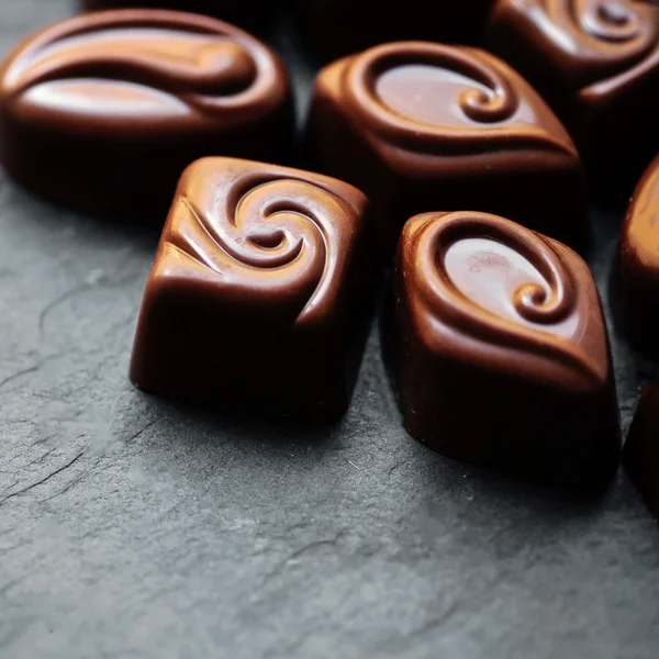 Deliciosos doces de chocolate. Chocolates como fundo. Doces de chocolate escuro. Doces pralinos . — Fotografia de Stock