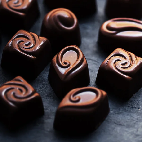 Coklat dengan latar belakang hitam. Permen coklat, Cocoa. Assortm — Stok Foto