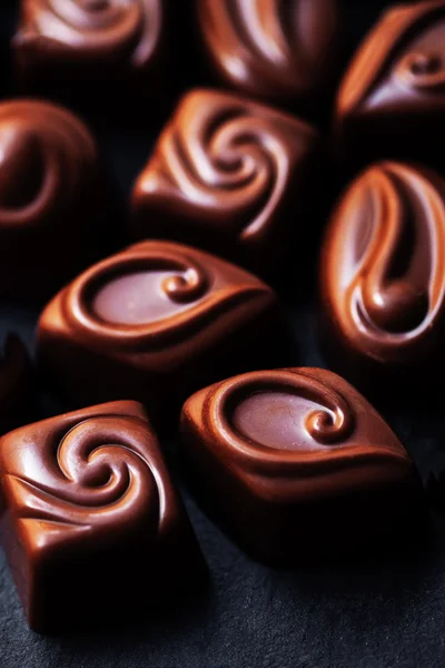 Chocolat sur fond noir. Bonbons au chocolat, cacao. Assortiment — Photo