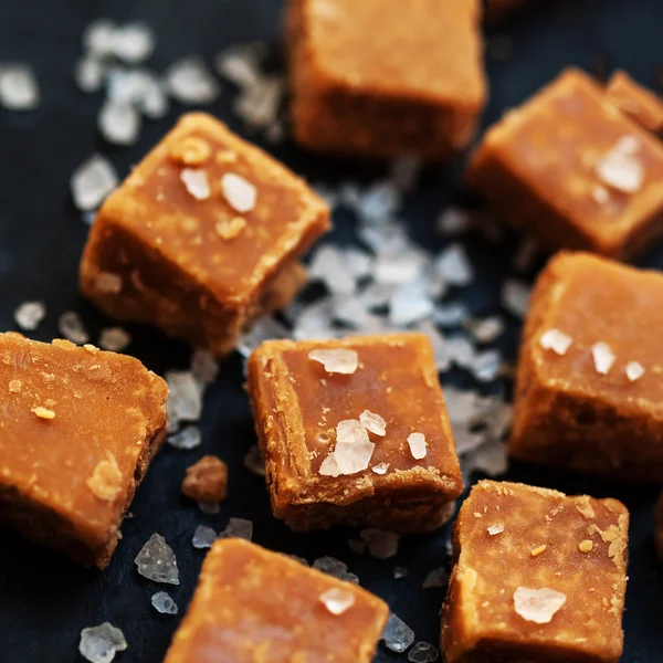 Salted caramel pieces and sea salt — Stock Photo, Image