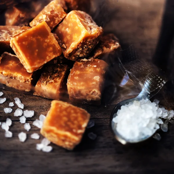 Pedaços de caramelo salgado e sal marinho — Fotografia de Stock