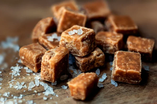 Salted caramel pieces and sea salt — Stock Photo, Image