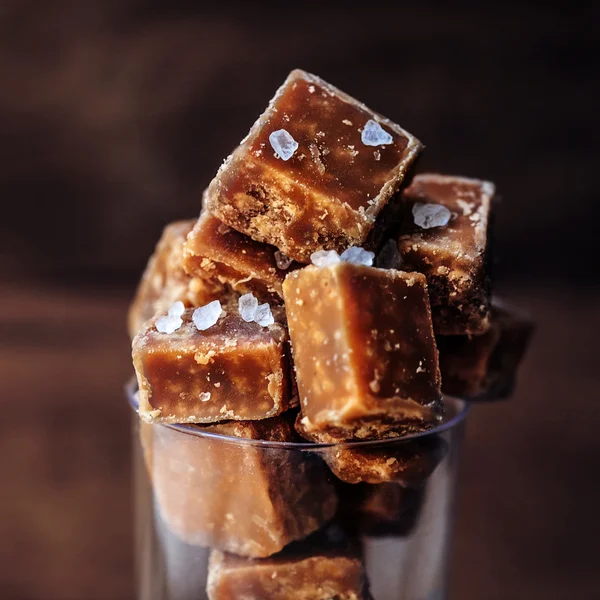 Salted caramel pieces and sea salt close up. Butter caramel cand Stock Photo by ©Zakharova 116467028