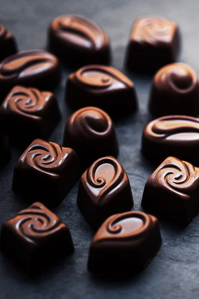 Dulces de chocolate sobre mesa negra — Foto de Stock