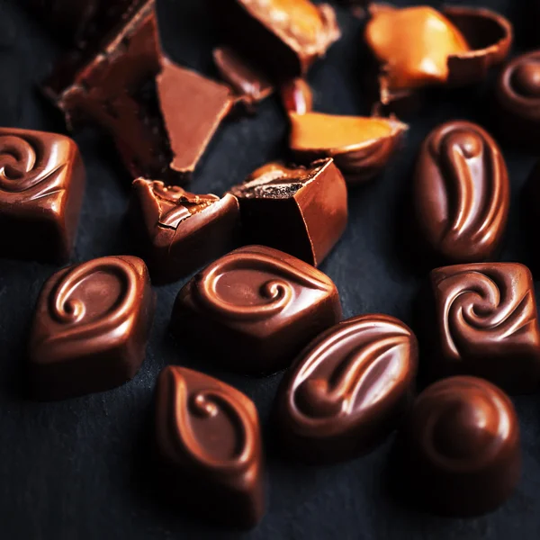 Doces de chocolate na mesa preta — Fotografia de Stock