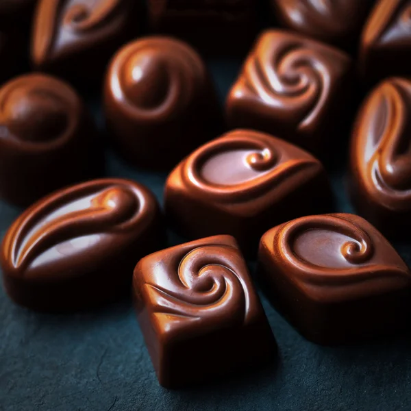 Doces de chocolate na mesa preta — Fotografia de Stock