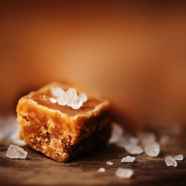 Salted caramel pieces and sea salt — Stock Photo, Image